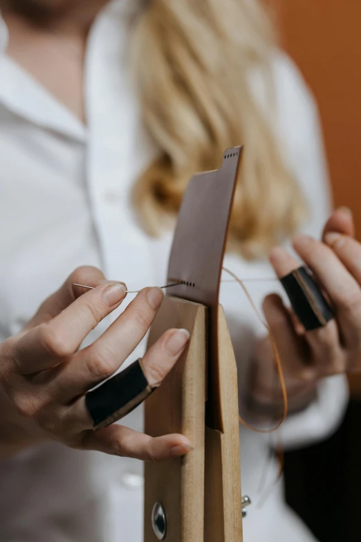 hands holding a leather knife set on a wooden table