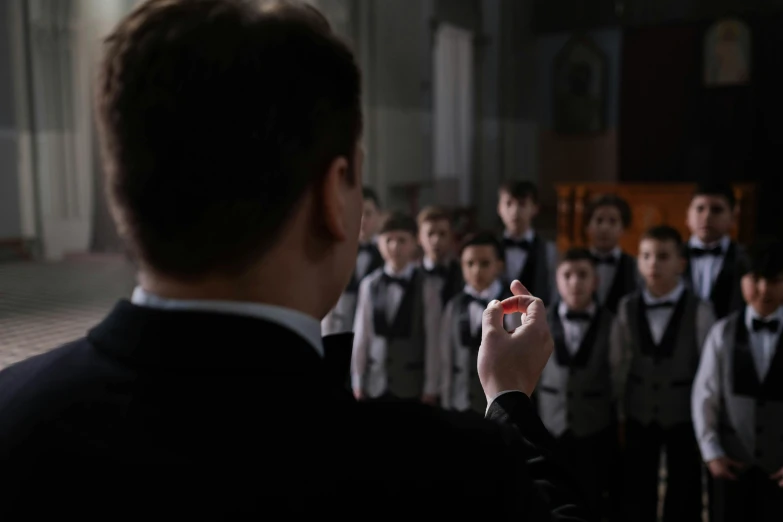 a group of school students stand in front of a conductor