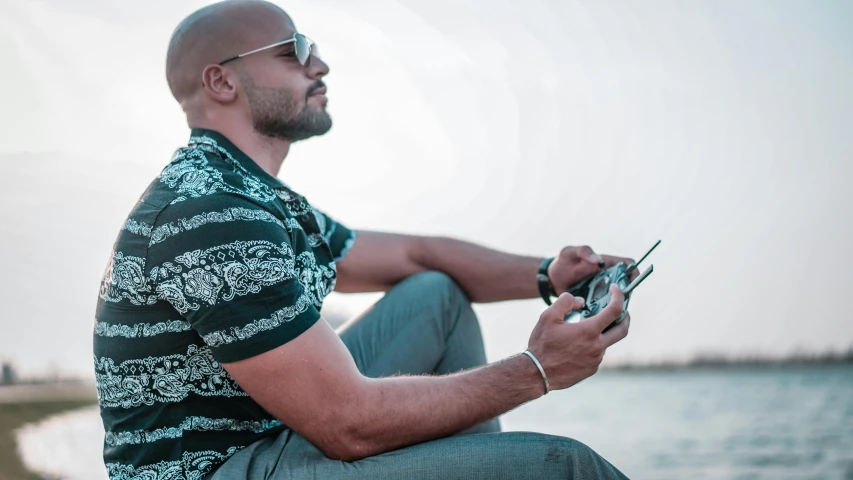 a man is sitting on the curb using a cell phone