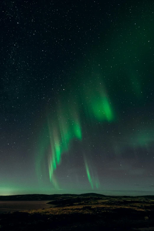 two green and white lights are shining in the sky