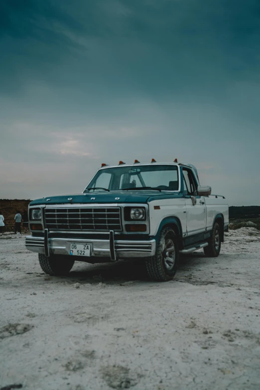 a large blue truck parked in a dirt field