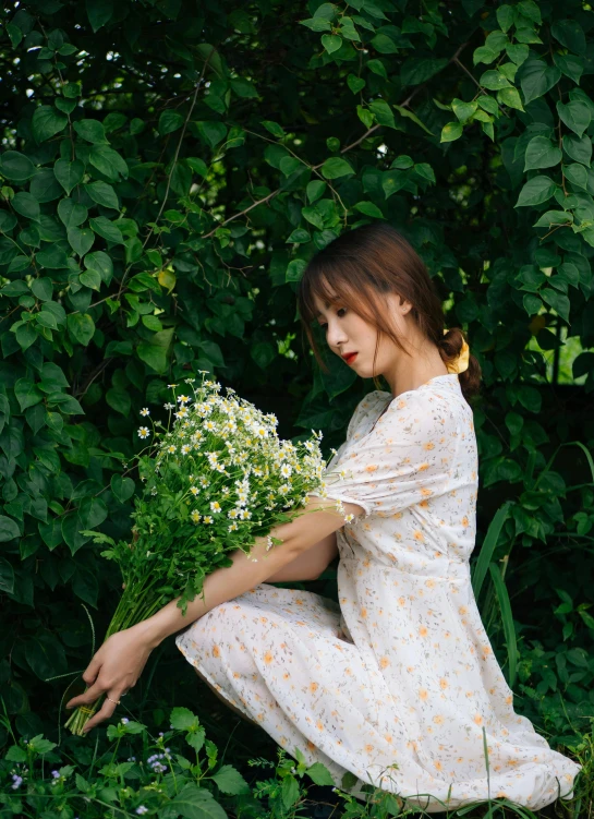 a girl in a floral dress kneeling on the ground