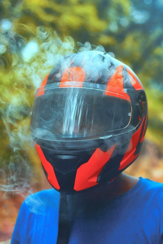 a motorcycle helmet on a person with smoke coming from the face