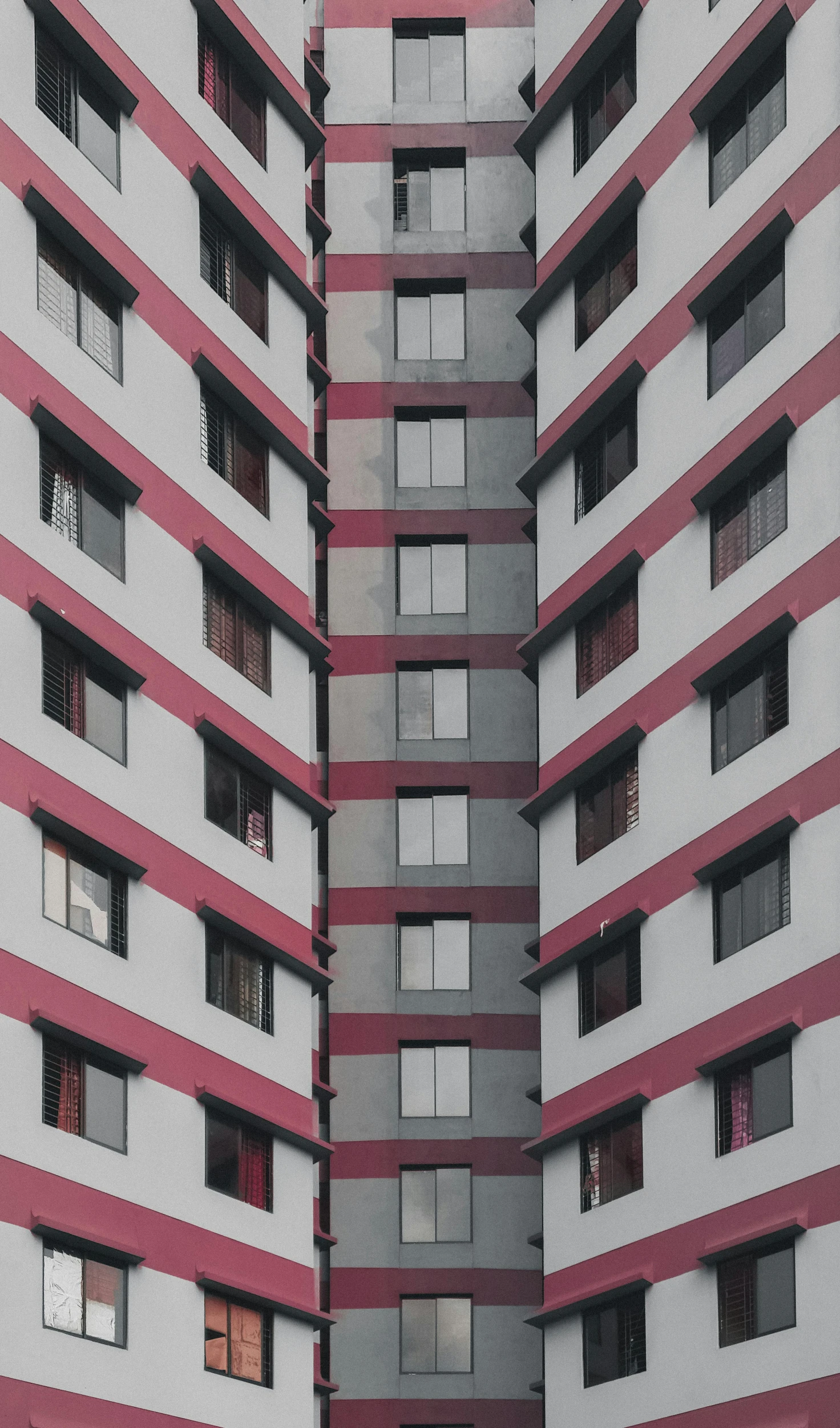 two windows in a grey and pink building