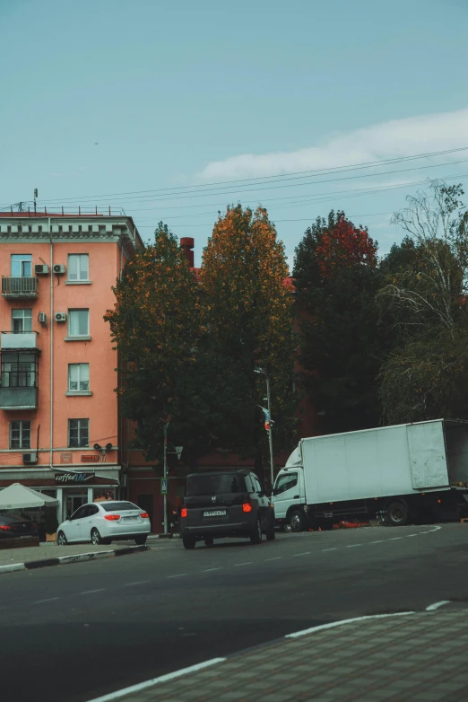 some cars are driving down a street in a city