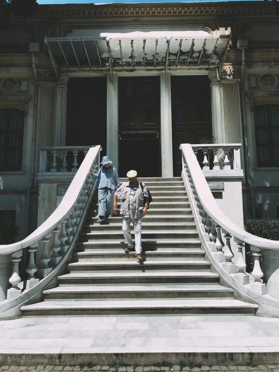 two people wearing masks, climbing down the stairs