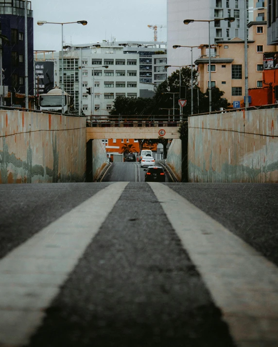 a road with two white striped stripes going through a tunnel