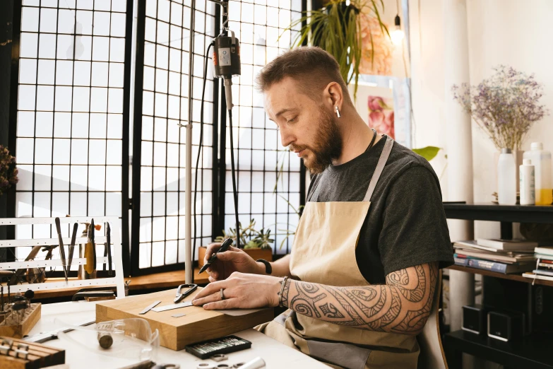 a man with a beard and piercings working on some scissors