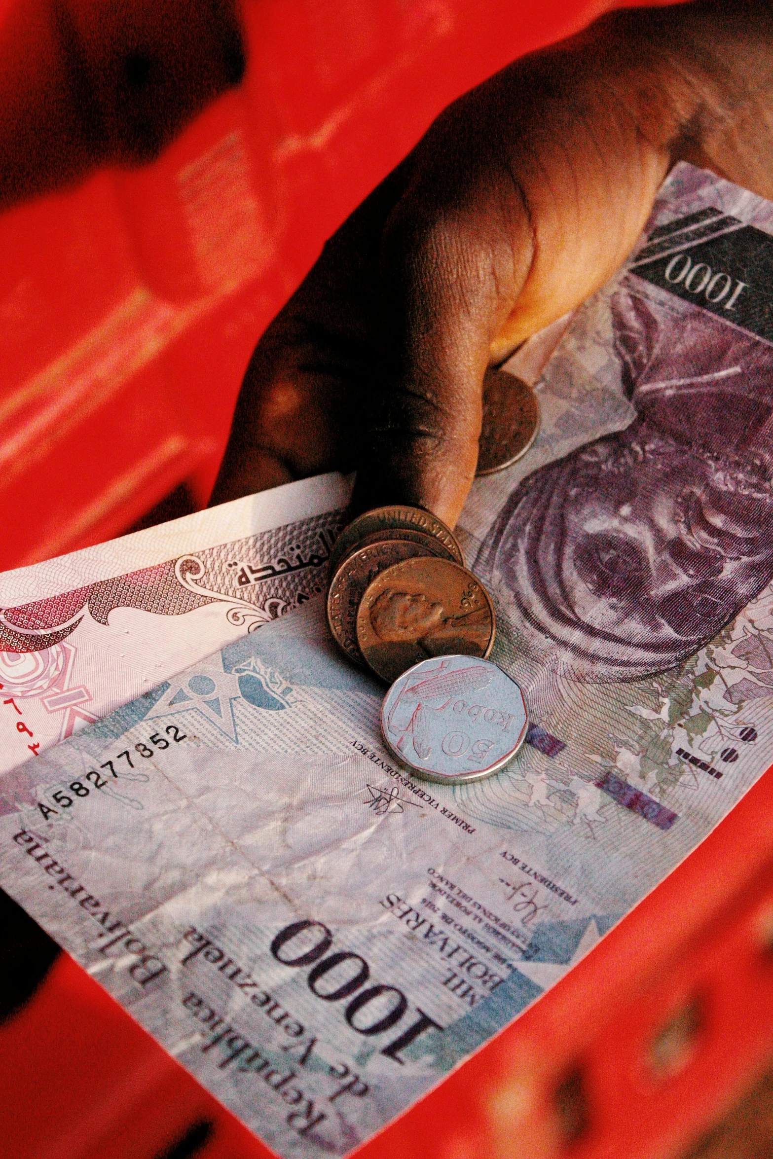 a person's hand putting euro coins into a purse