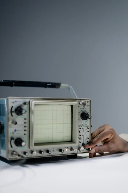 a person touching an old fashioned analog radio