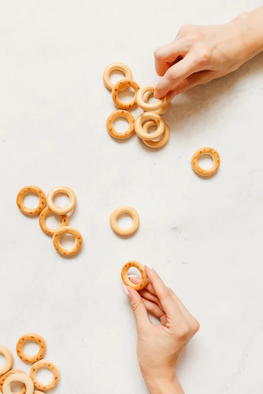 several hand - made small rings sitting on a table next to one person