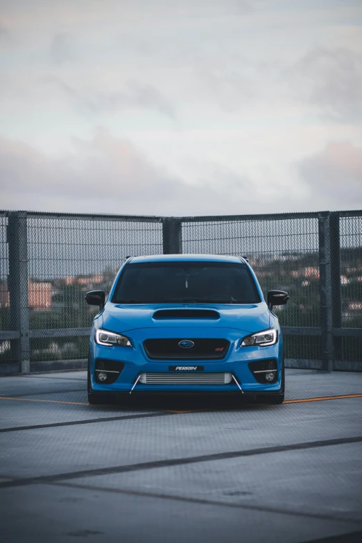 a blue subarun driving on an asphalt road