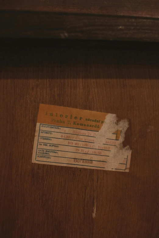 a ticket with writing on it in front of a wooden table