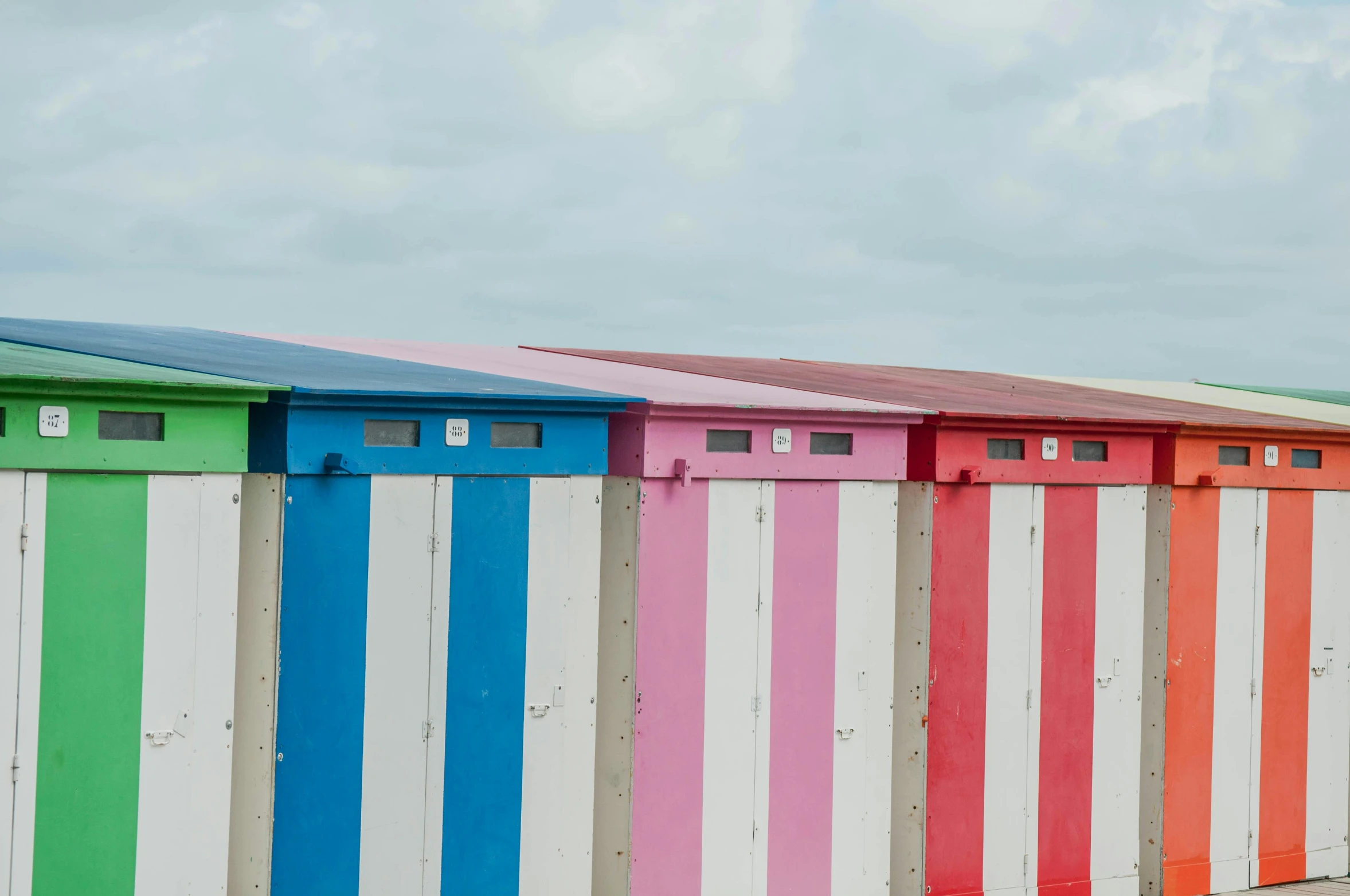 the beach is lined with brightly painted fences