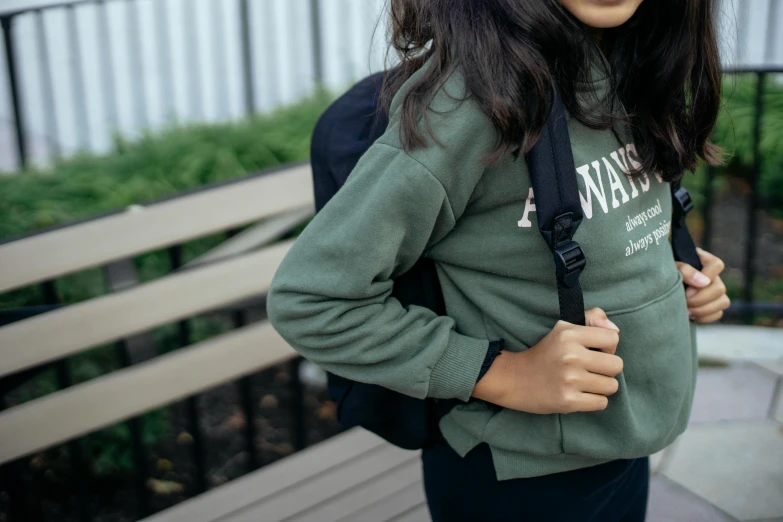 a woman with a backpack standing next to a bench