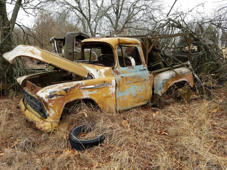 an old truck parked in some dried grass