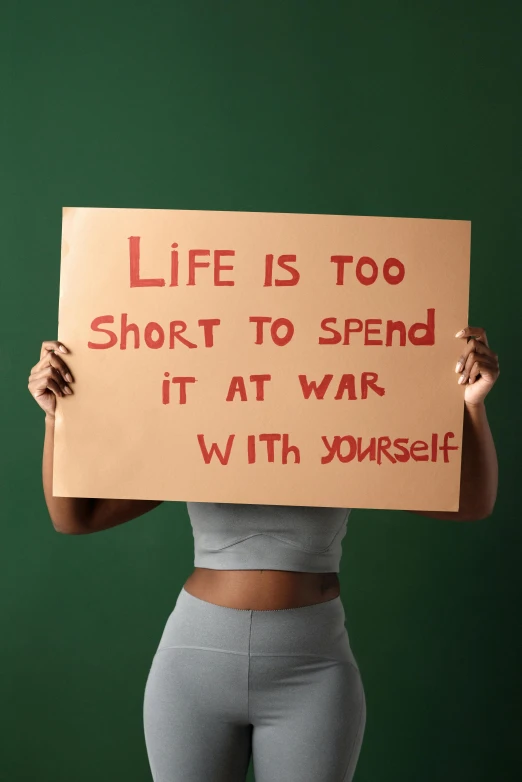 a woman holding a sign with the phrase life is too short to spend it at war