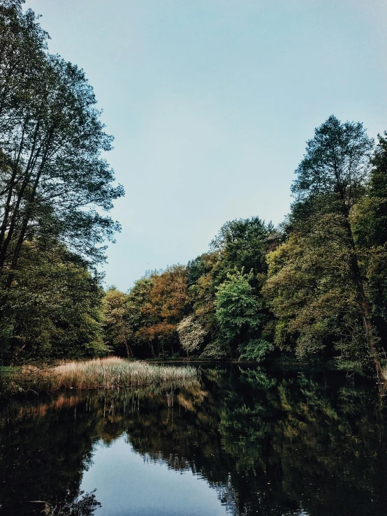 the sky is reflecting in the still waters