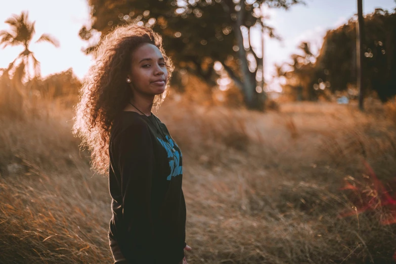 a woman posing for a picture in a field