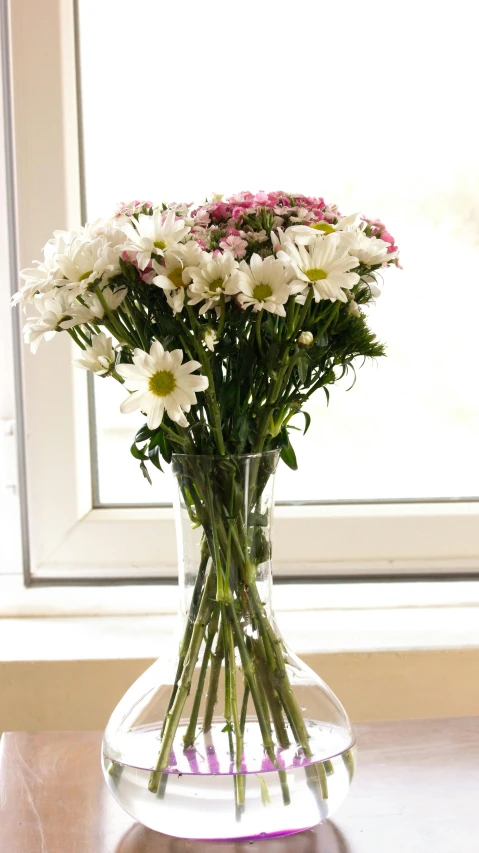 a vase filled with white and pink flowers