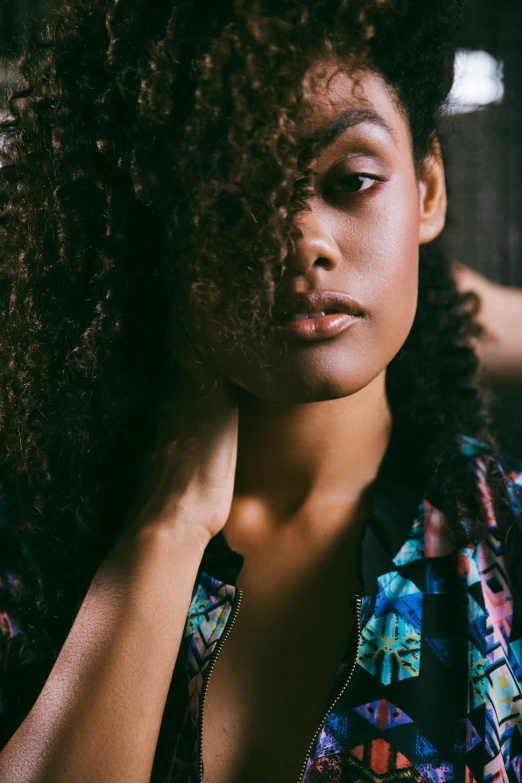 a woman with curly hair sitting down in a room