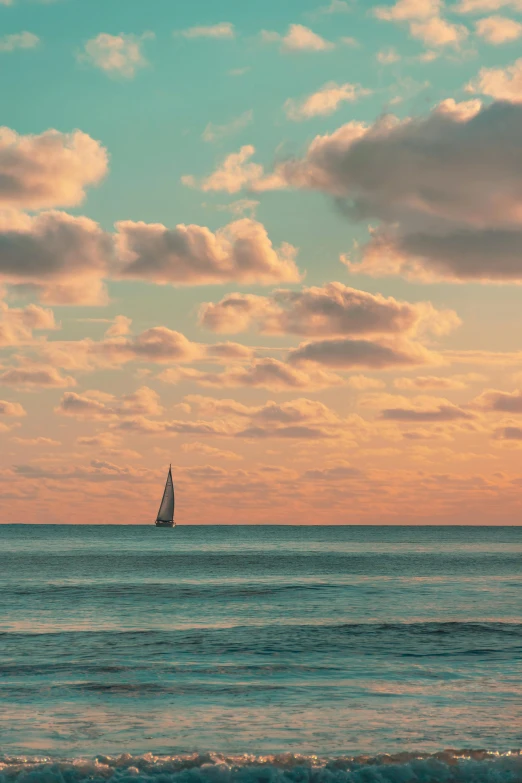 a sailboat sailing in a body of water under a cloudy sky