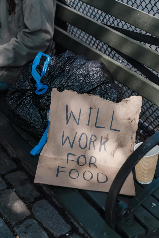 a sign on a park bench that reads will work for food