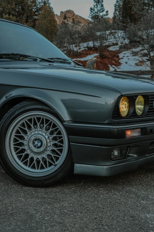 a black bmw sports utility car parked in front of a rocky mountain