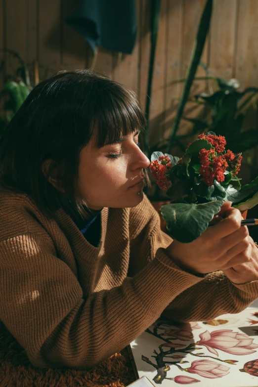 a woman smelling a bouquet of flowers in a house