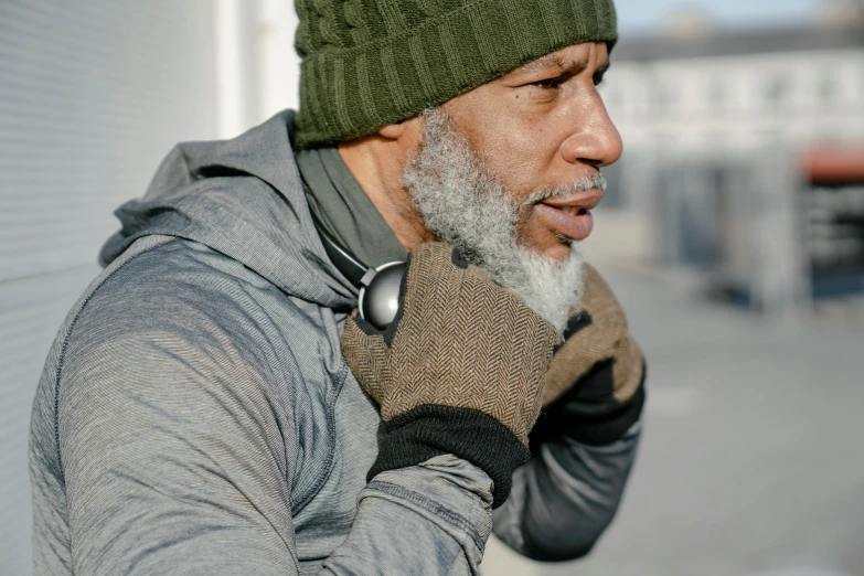 a bearded man talking on a cell phone wearing a knit hat