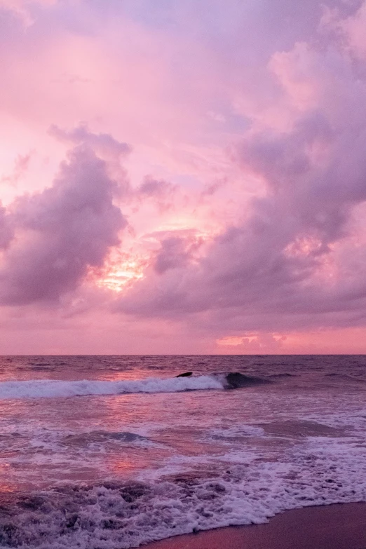 a pink sky that is above the ocean