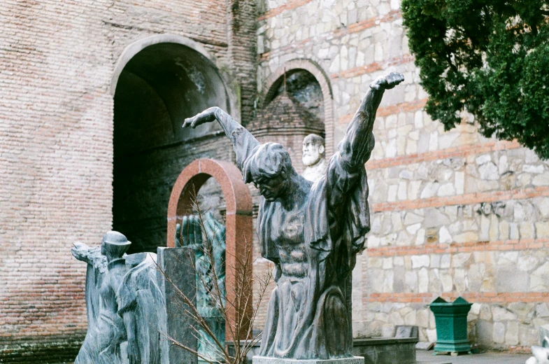 a statue stands in front of the courtyard of an old building