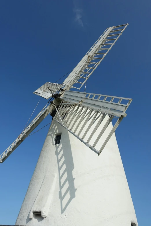 a white windmill with a metal fence around it