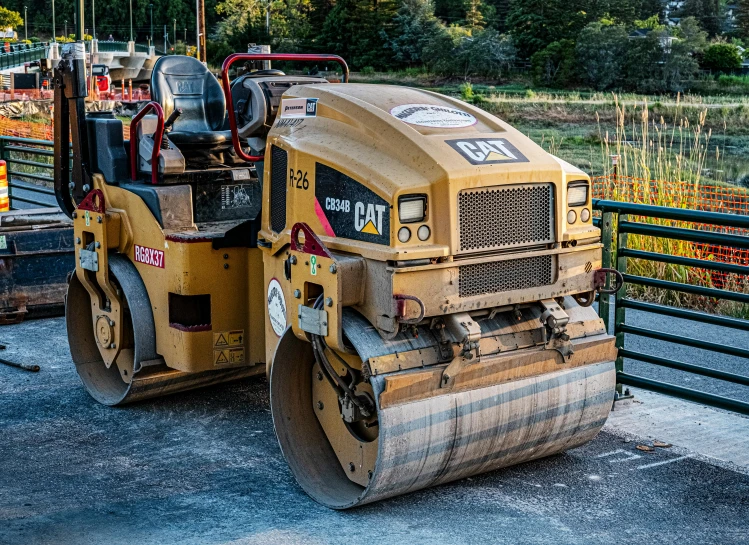 a small road roller parked next to a parking lot