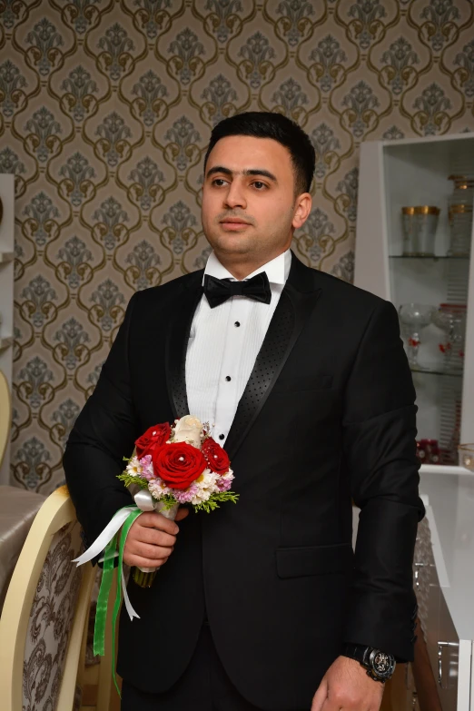 a man in a suit holds a bouquet of flowers