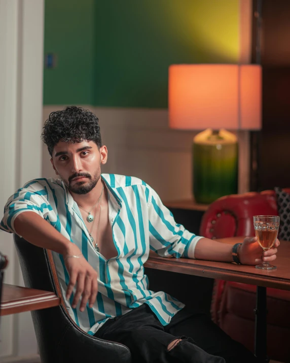 a young man in striped shirt sitting at wooden table