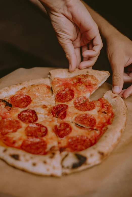 someone cuts pizza from a pizza on top of the table