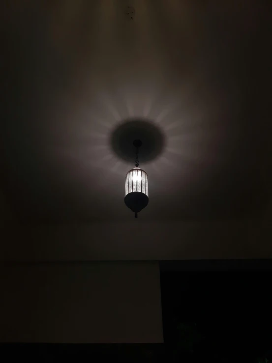 a light fixture illuminated in the middle of a room