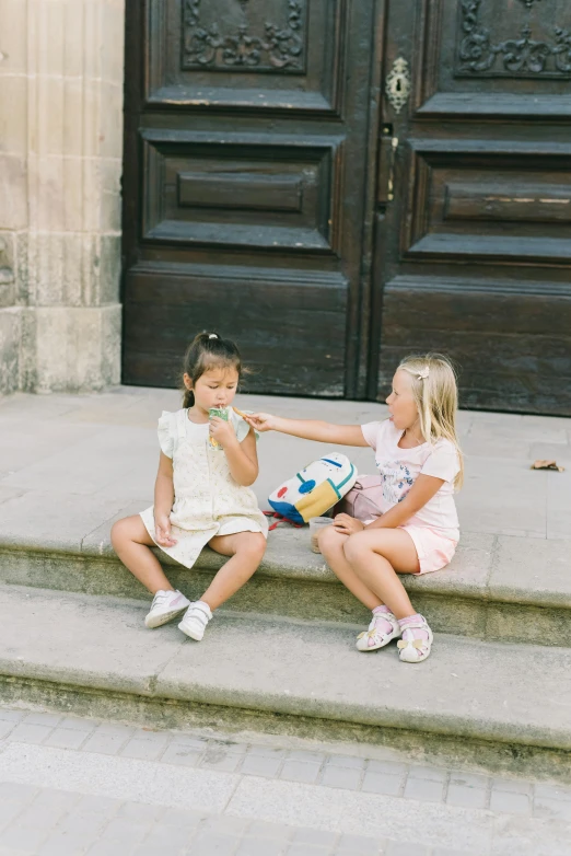 two s sitting on steps outside the door of a church