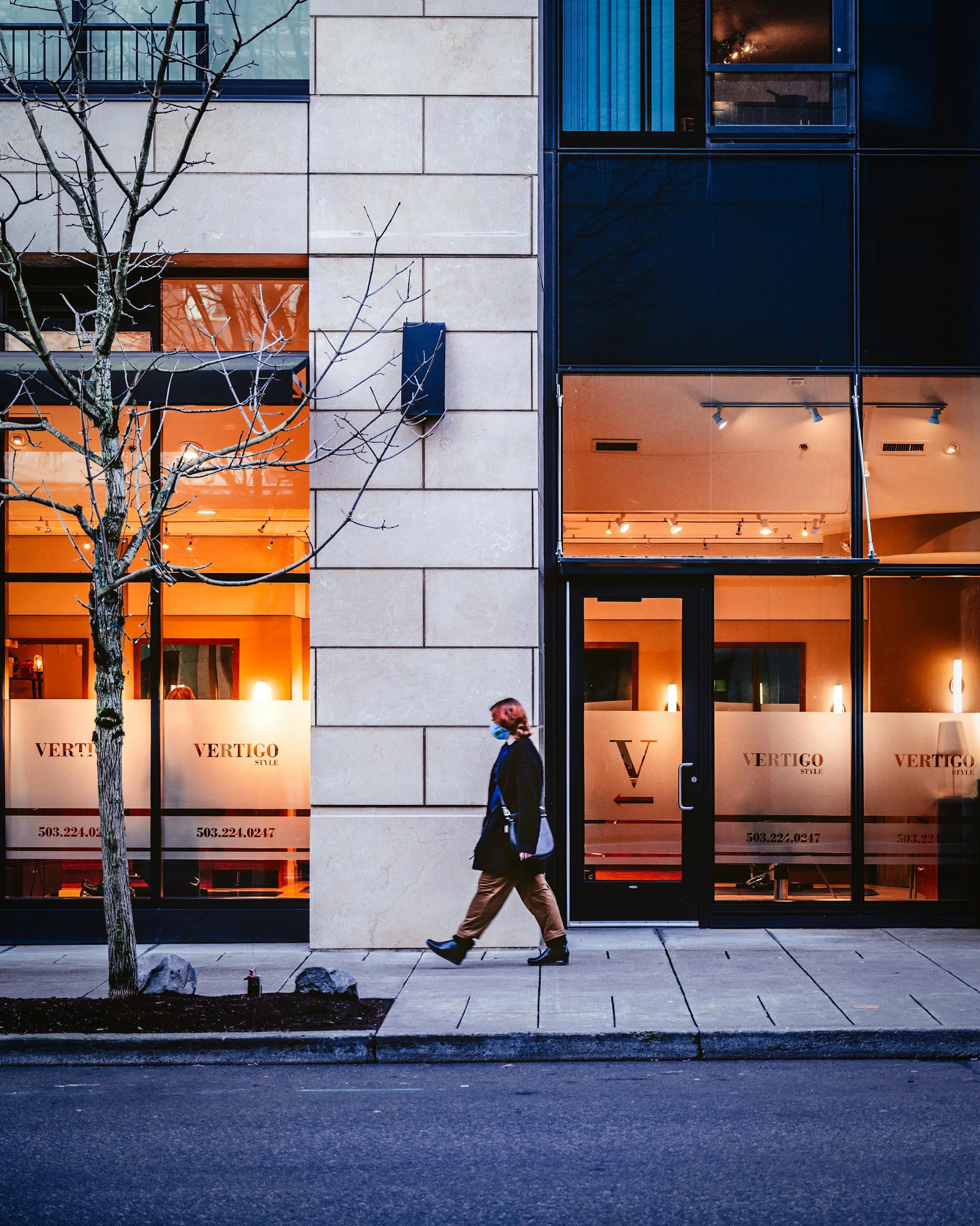 a person walking down the street in front of a building