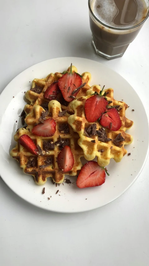 a plate that has some waffles with strawberries