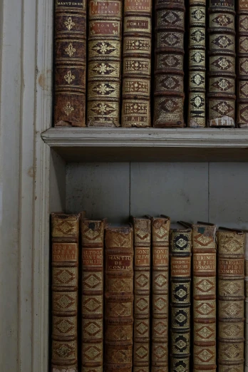 this is a shelf in a bookshelf with books stacked above