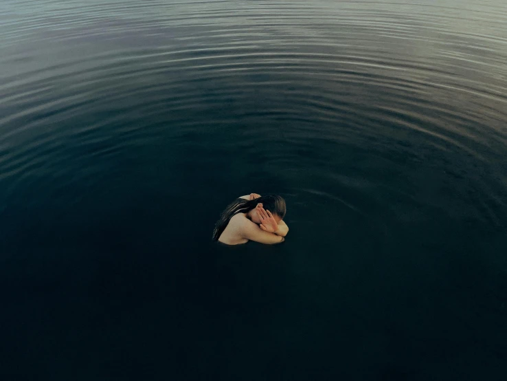a man is swimming alone on the water