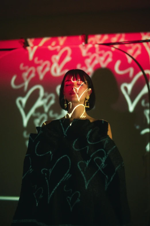 a person's shadow projected on a wall with pink, green and blue letters on it