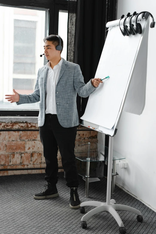 a man points to soing on a dry erase board