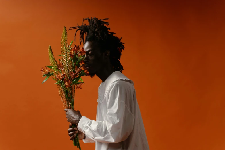 a black man holding flowers and looking to his left