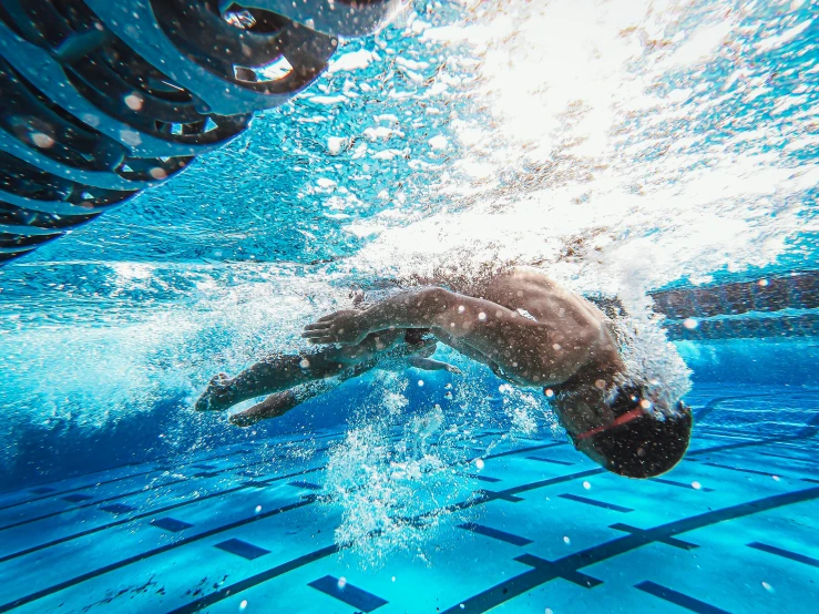 a man swimming in a pool under water