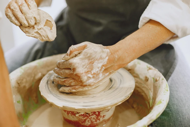 a woman is spinning dough on a potter's wheel