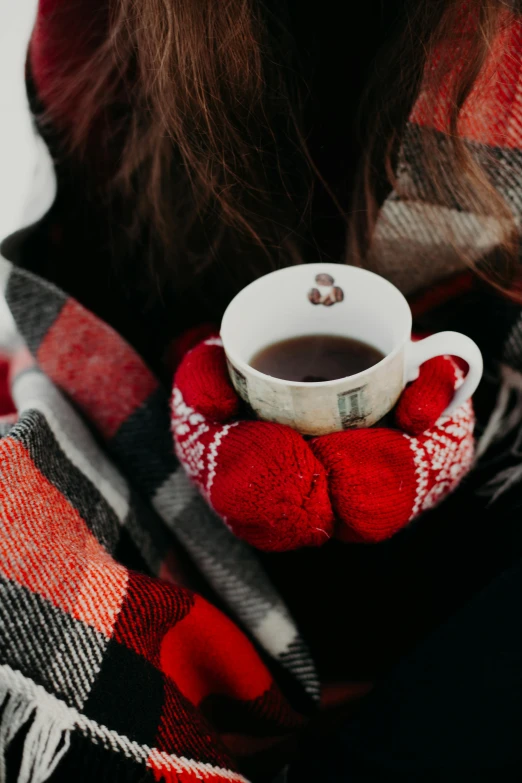 a woman is holding a mug of coffee on her lap