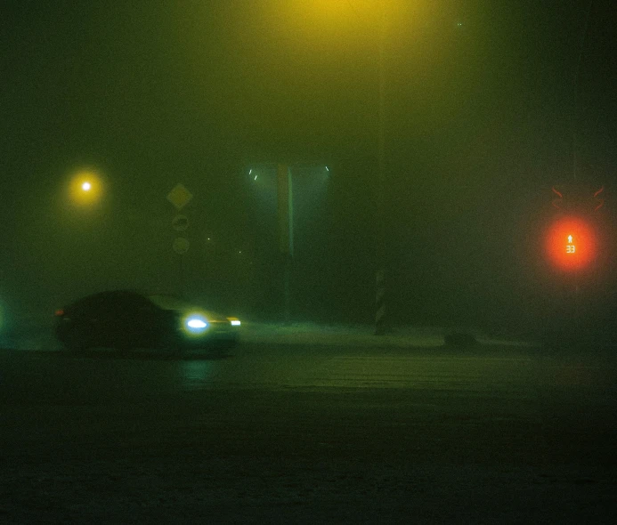cars driving through a dark street at night time